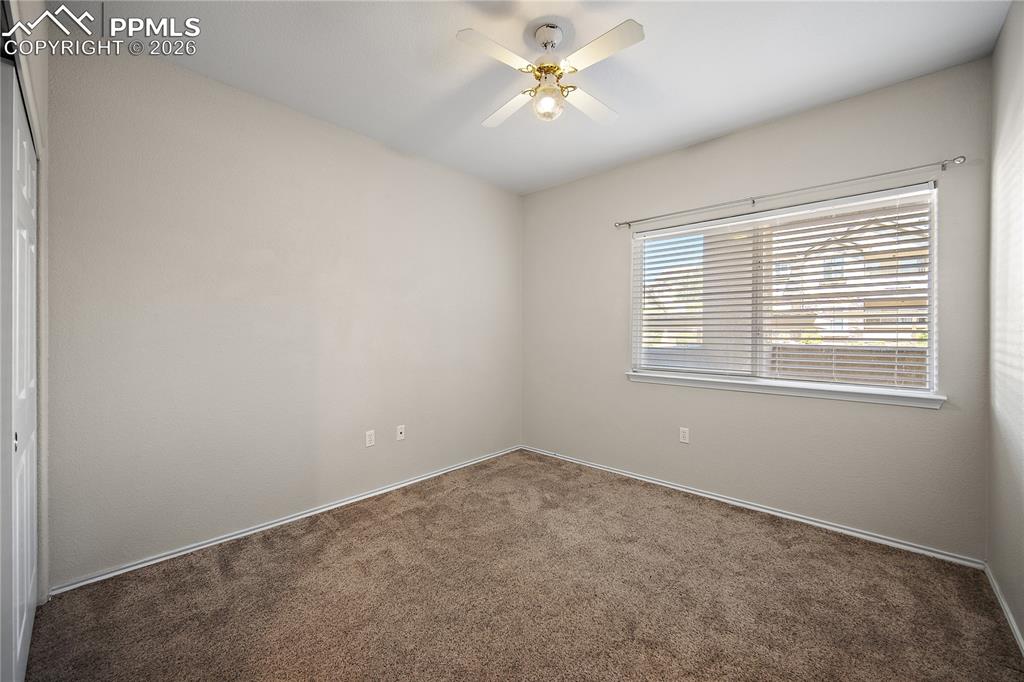 Image 28 of 31: Carpeted room featuring a single window with blinds, a ceiling fan with lig