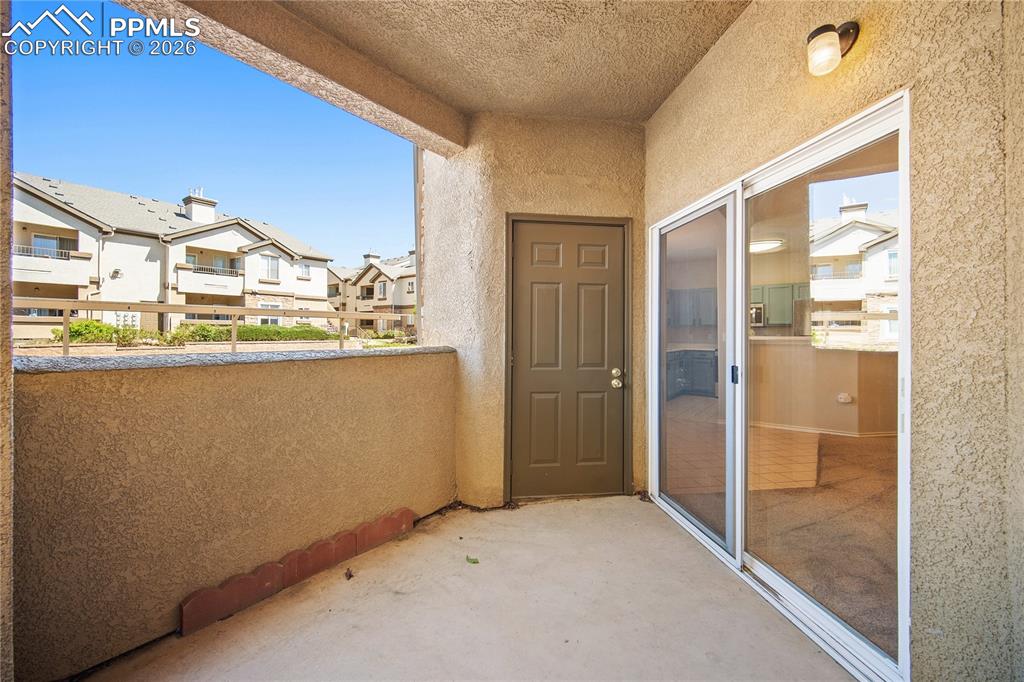 Image 31 of 31: Private balcony featuring concrete flooring, stucco walls, an exterior ligh
