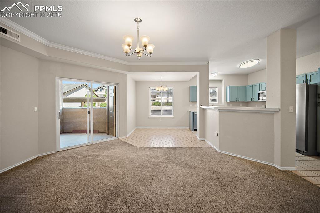 Image 8 of 31: Open-concept living area featuring a sliding glass door to a private balcon