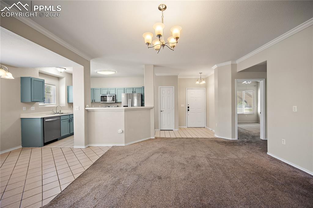Image 9 of 31: Open concept living space featuring neutral wall tones and crown molding