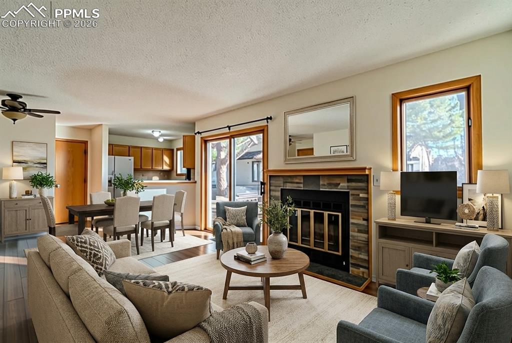 Image 12 of 26: Living room featuring a fireplace with flush hearth, light wood-style floor