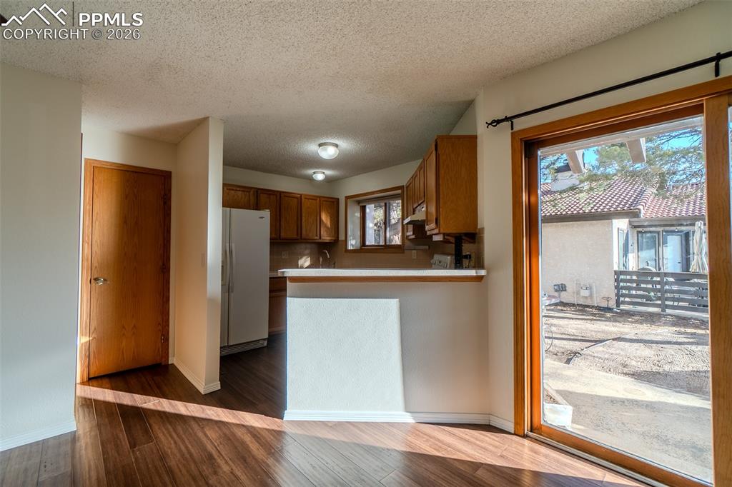 Image 17 of 26: Kitchen featuring wood finish cabinets, white refrigerator with ice dispens