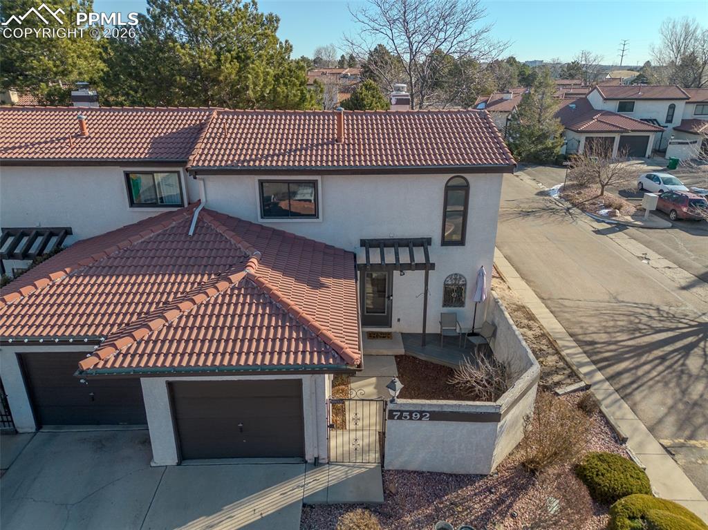 Image 2 of 26: View of front facade featuring a chimney, stucco siding, a gate, a tiled ro
