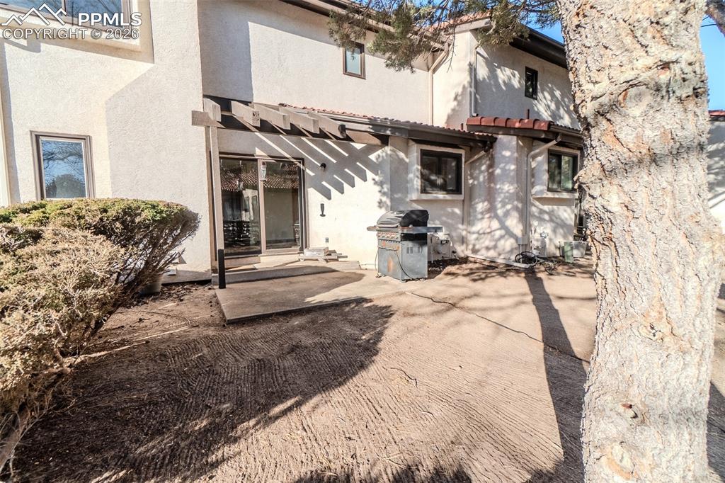 Image 23 of 26: Back of house with stucco siding, a patio area, and a tiled roof