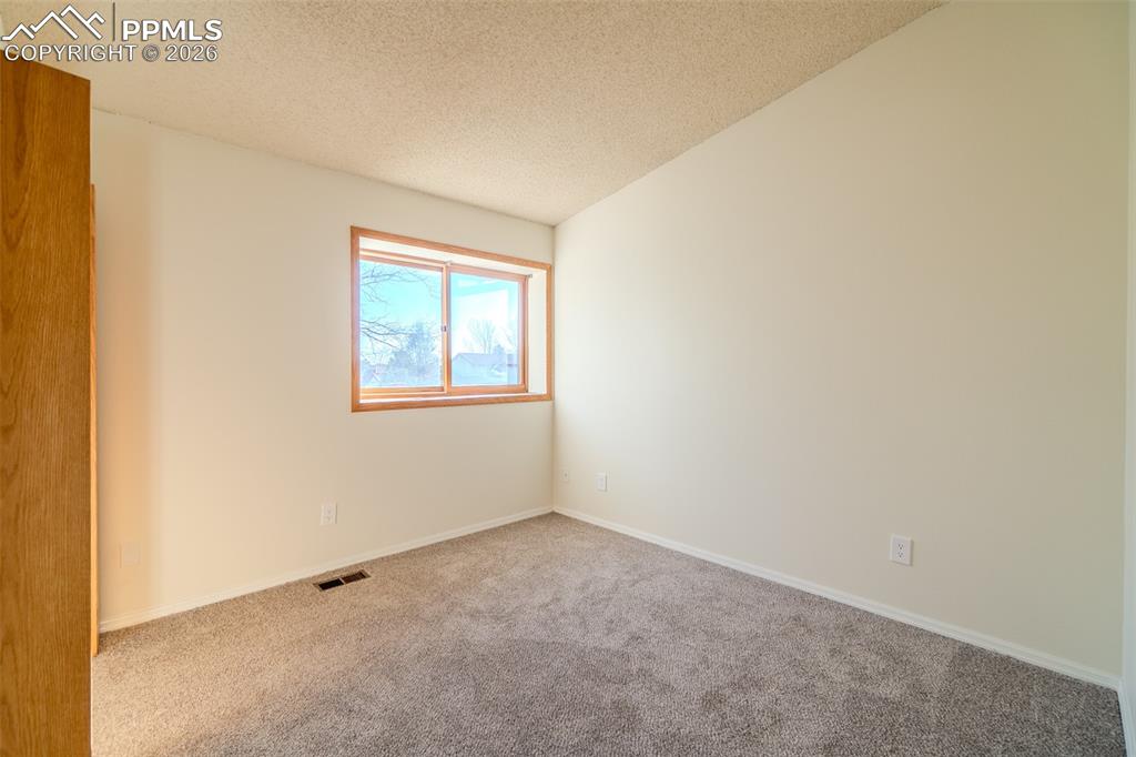 Image 5 of 26: Spare room featuring carpet and baseboards