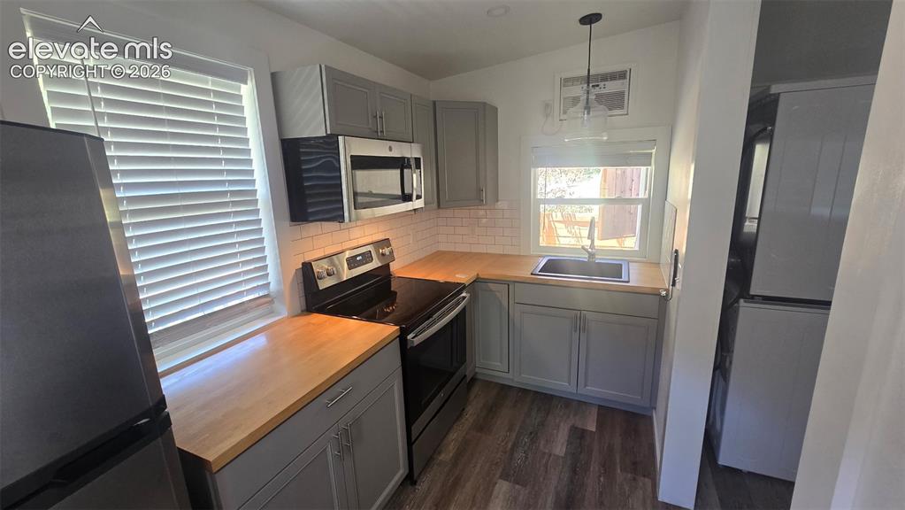 Image 14 of 43: Kitchen featuring wood-finish countertops, stainless steel appliances, a su
