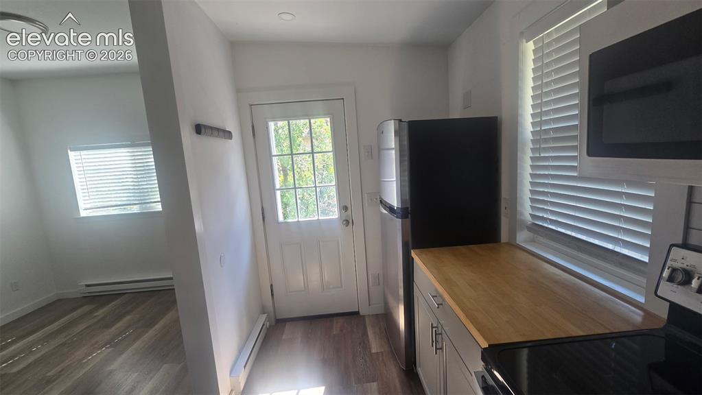 Image 17 of 43: Wood-finish flooring, white walls, and a white paneled door with glass inse