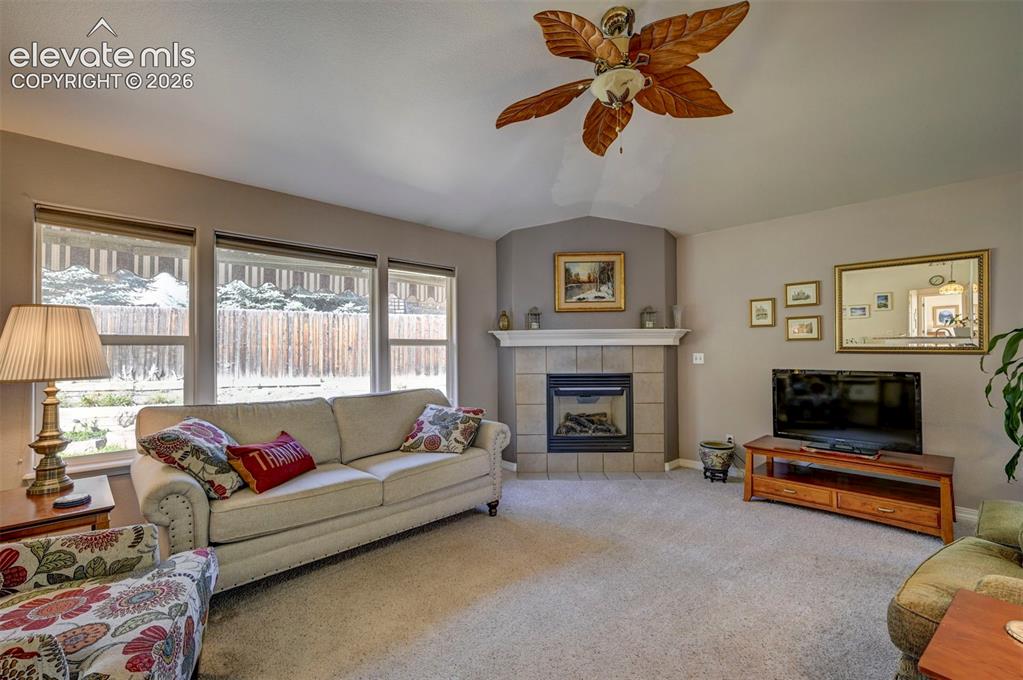 Image 19 of 50: Open plan living: Living room with lofted ceiling, a gas fireplace, and nat