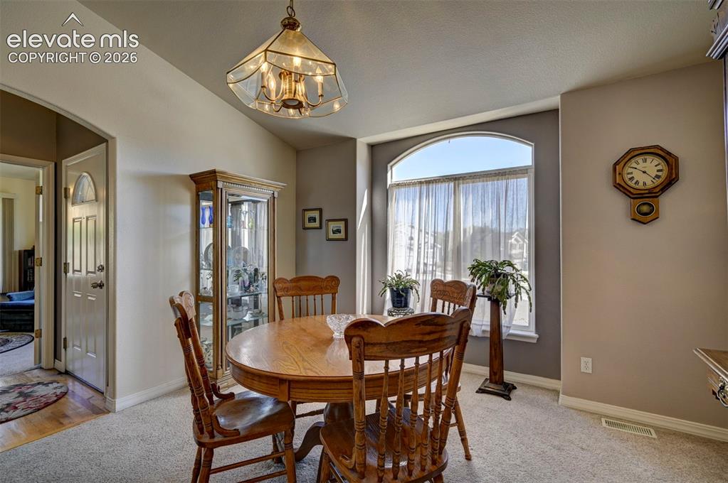 Image 7 of 50: Dining room overlooking front yard view.