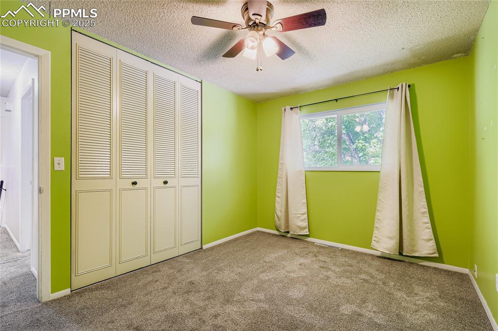Image 16 of 28: Unfurnished bedroom featuring carpet flooring, a closet, ceiling fan, and a