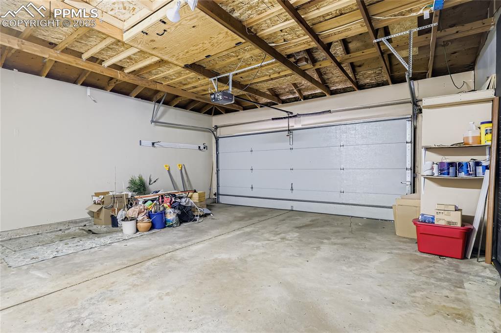 Image 25 of 28: Garage featuring a garage door opener