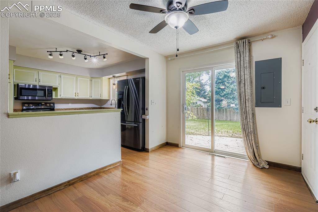 Image 8 of 28: Kitchen with electric panel, light wood-type flooring, black appliances, a 