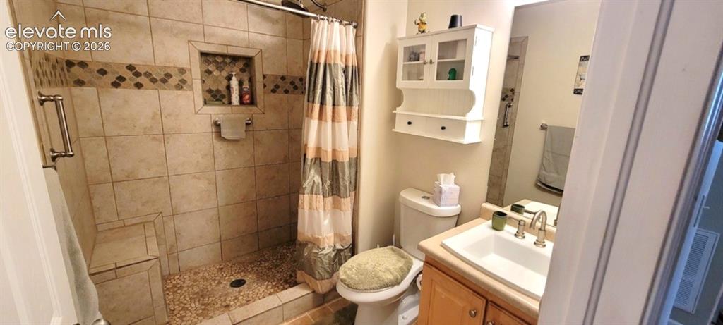 Image 22 of 24: Remodeled bath with river rock tile flooring