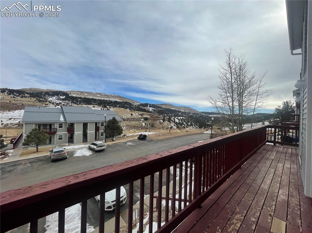 Image 18 of 24: Snow covered deck with a mountain view
