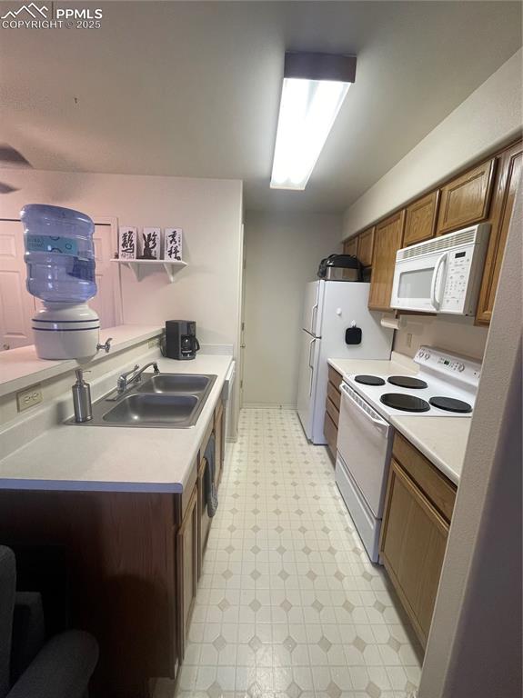 Image 8 of 24: Kitchen with sink, dishwashing machine, stove, and fridge