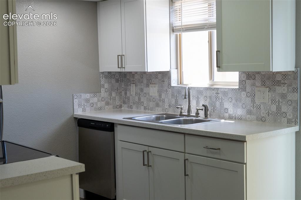 Image 10 of 31: Modern kitchen featuring white shaker cabinetry, light-toned countertops, a