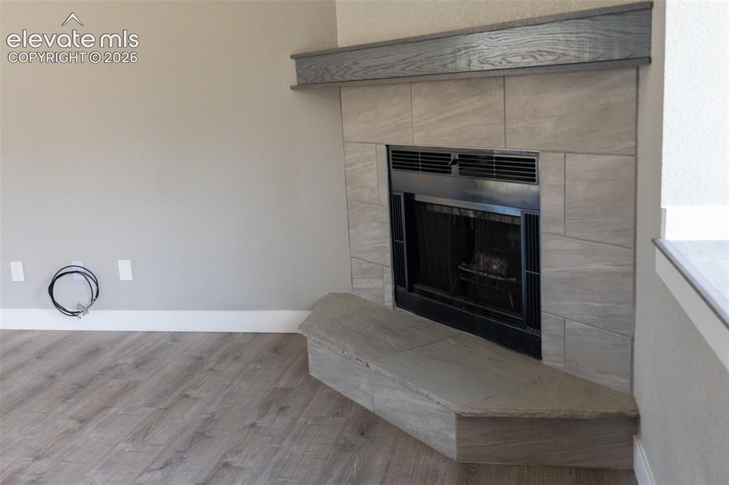 Image 12 of 31: Fireplace featuring a slate tile surround, dark wood-finish mantel, and a b