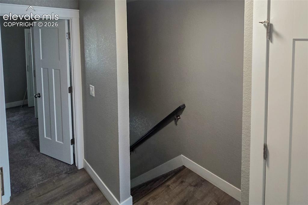 Image 16 of 31: Hallway featuring wood-finish flooring, crisp white trim, and a contemporar