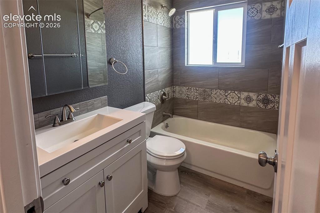 Image 17 of 31: Bathroom featuring a white vanity with integrated sink, brushed nickel fixt