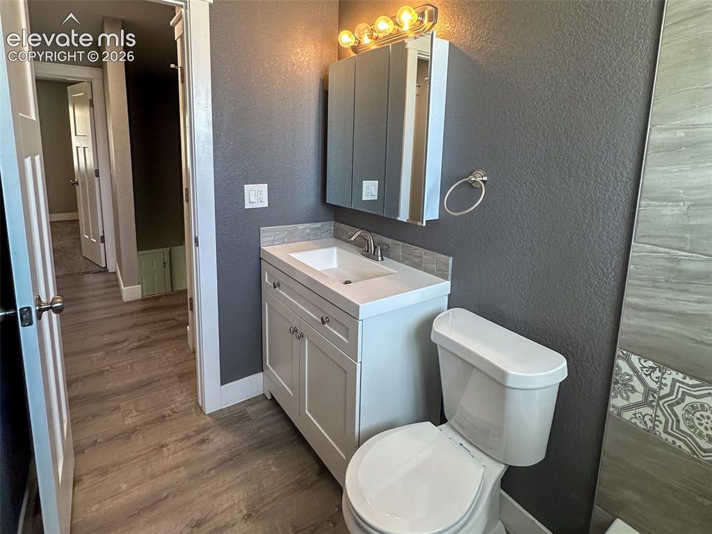Image 18 of 31: Bathroom featuring a white vanity with integrated sink, chrome faucet, and