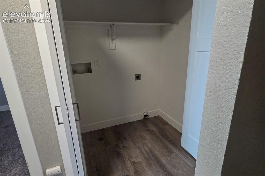 Image 19 of 31: Dedicated laundry alcove featuring wood-finish flooring, white baseboards,