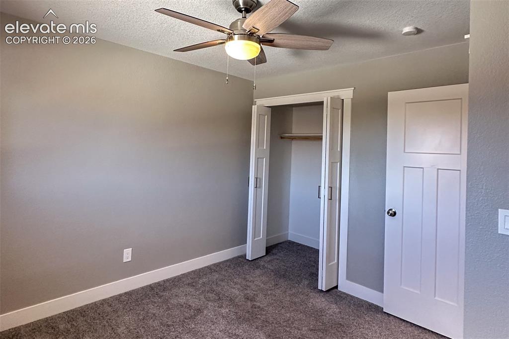 Image 20 of 31: Carpeted room featuring a ceiling fan with light fixture, bifold closet doo