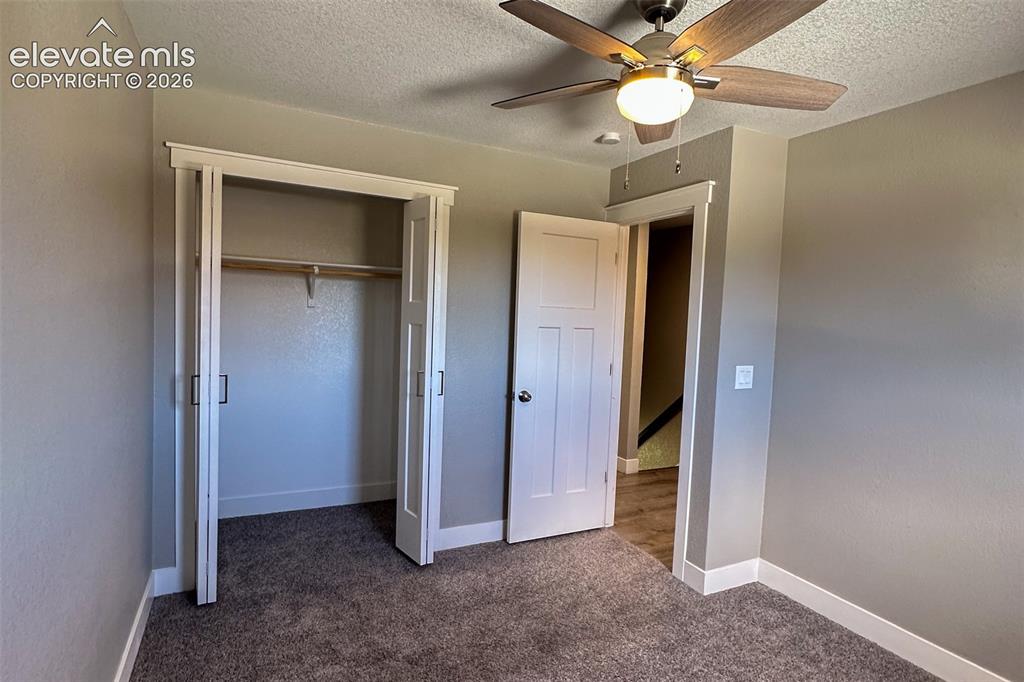 Image 21 of 31: Carpeted room featuring a ceiling fan with light fixture, bi-fold closet do