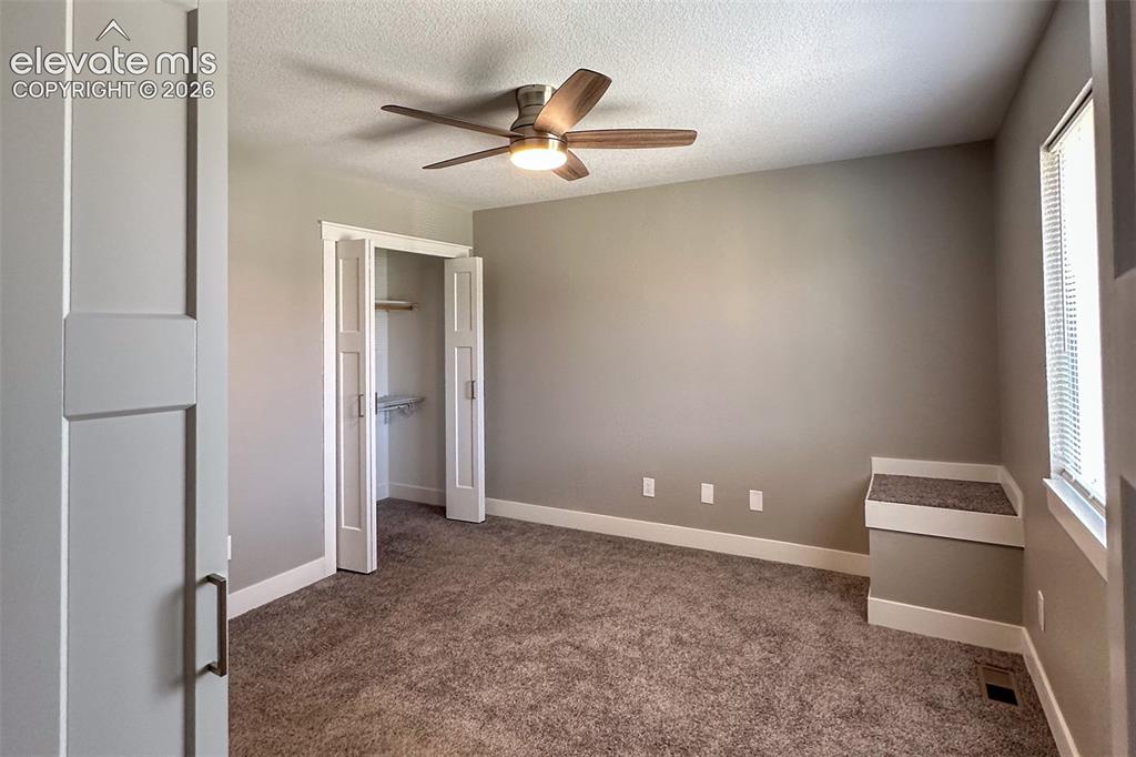 Image 22 of 31: Carpeted room featuring a ceiling fan with integrated lighting, a built-in