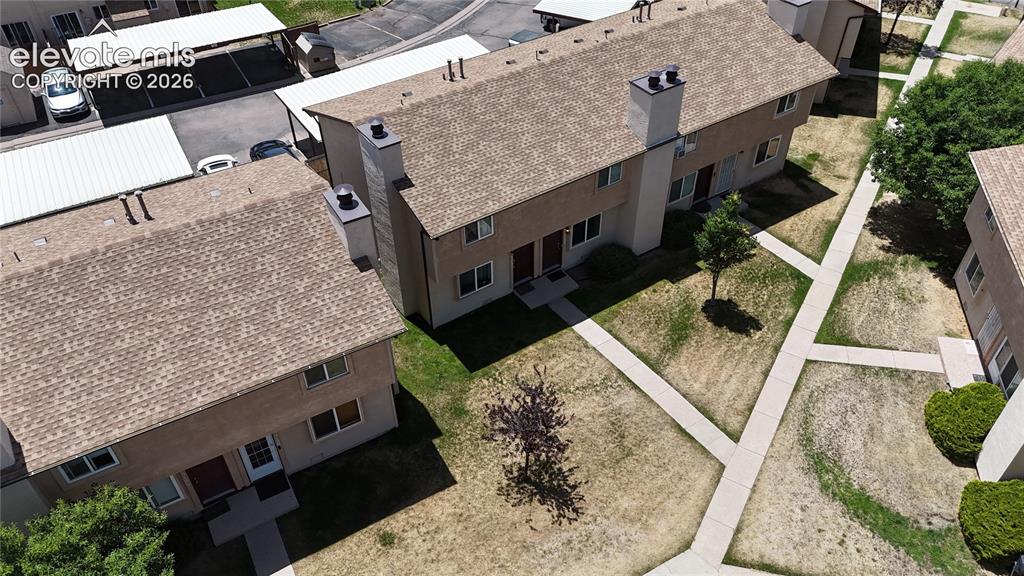 Image 3 of 31: Aerial perspective of multiple stucco-sided townhomes featuring shingle roo