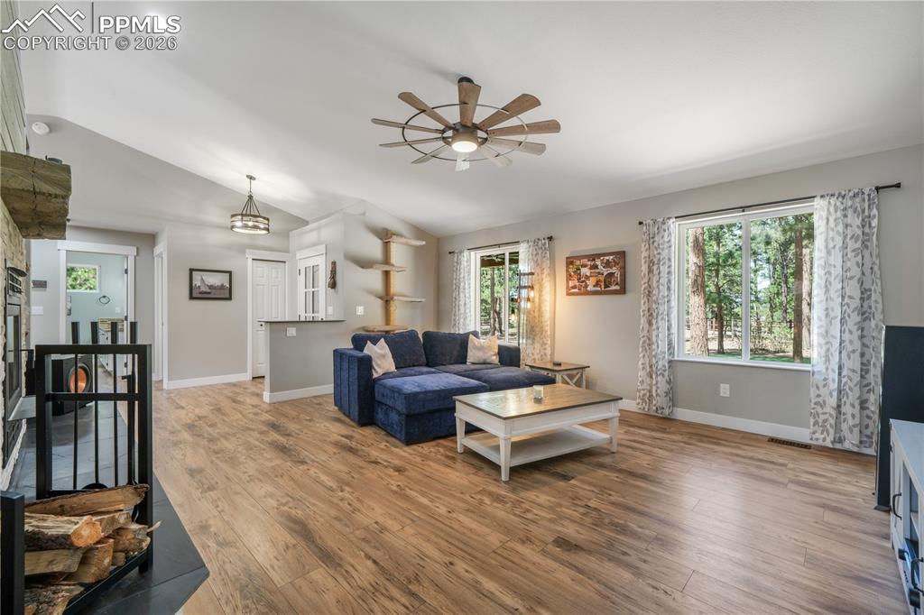 Image 10 of 50: Main level open concept living room with new floors, wood burning fireplace