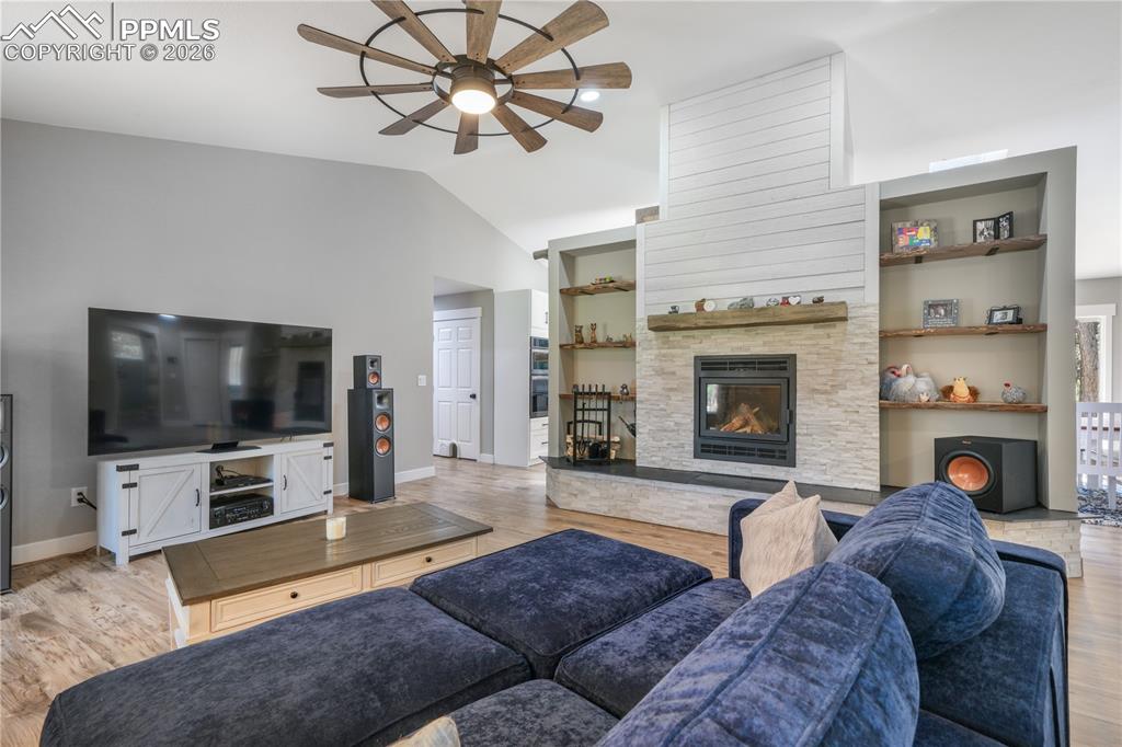 Image 11 of 50: Main level open concept living room with new floors, wood burning fireplace