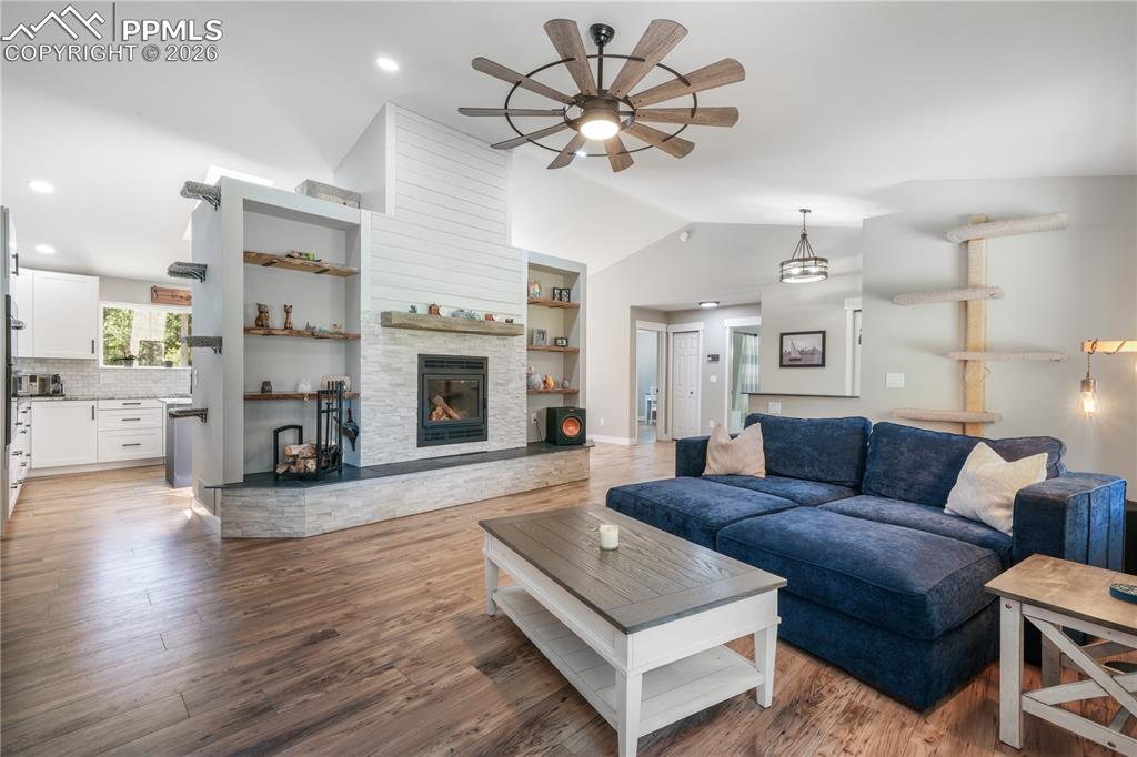 Image 12 of 50: Main level open concept living room with new floors, wood burning fireplace