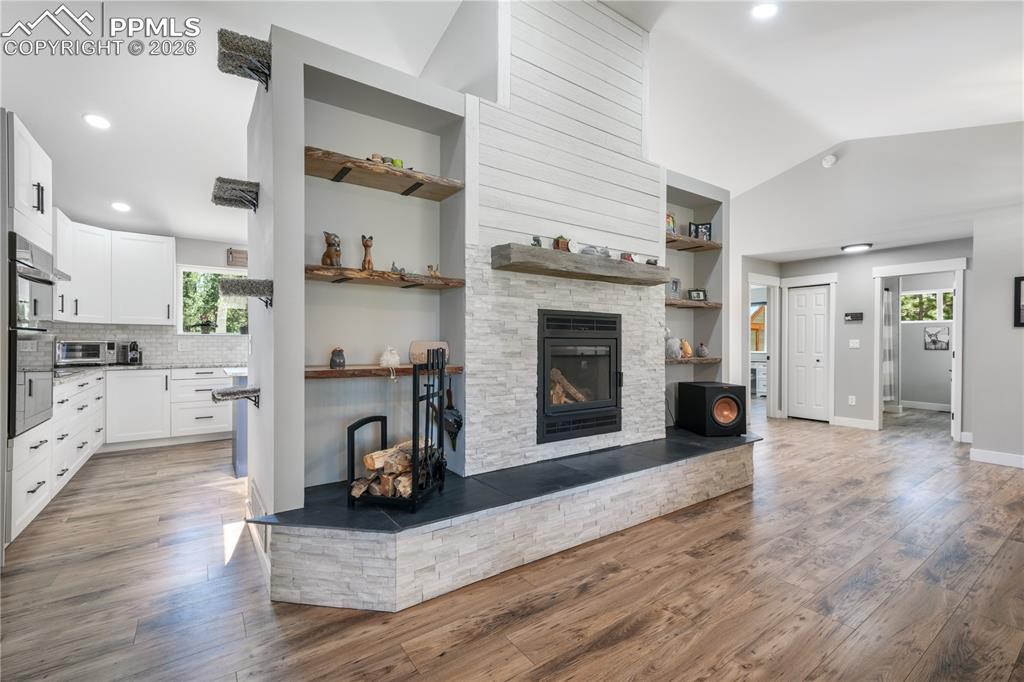 Image 13 of 50: Main level open concept living room with new floors, wood burning fireplace