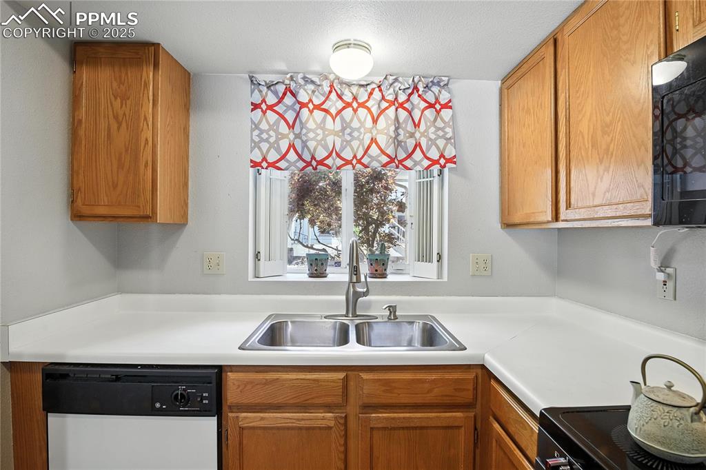 Image 13 of 25: Kitchen is light and bright with a lovely view of the plum tree in the fron
