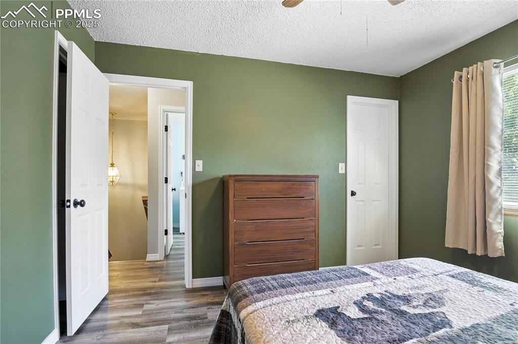 Image 19 of 25: Bedroom featuring wood finished floors, a textured ceiling, and ceiling fan