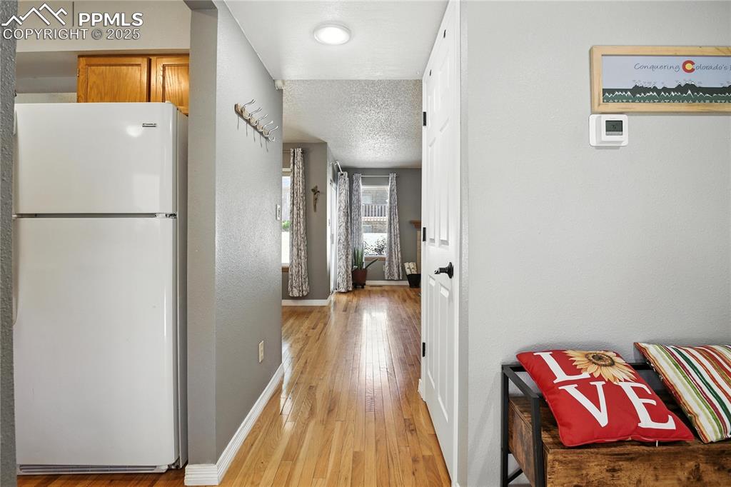Image 4 of 25: Hallway featuring light wood flooring and a textured ceiling