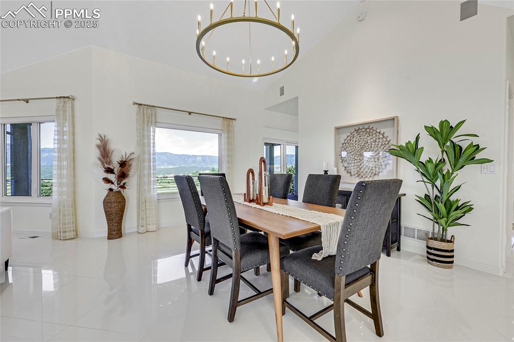 Image 10 of 48: Dining room featuring a chandelier, light tile patterned flooring, and a hi