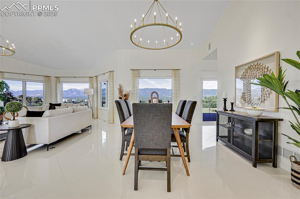 Image 11 of 48: Dining room featuring a chandelier, light tile patterned floors, a mountain