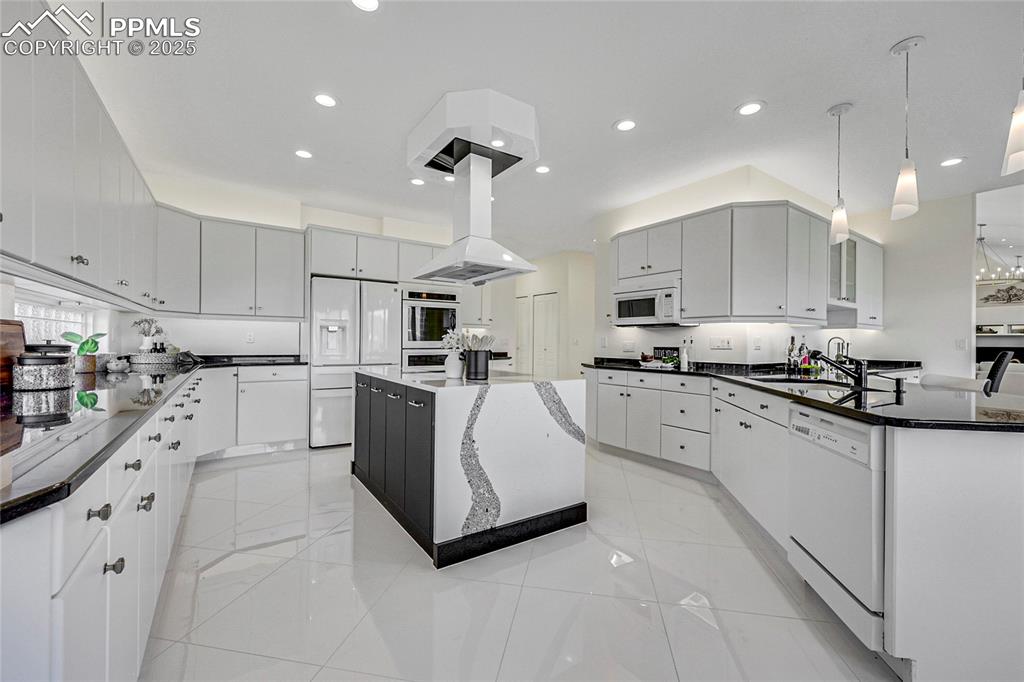 Image 15 of 48: Kitchen featuring white appliances, recessed lighting, a center island, dec