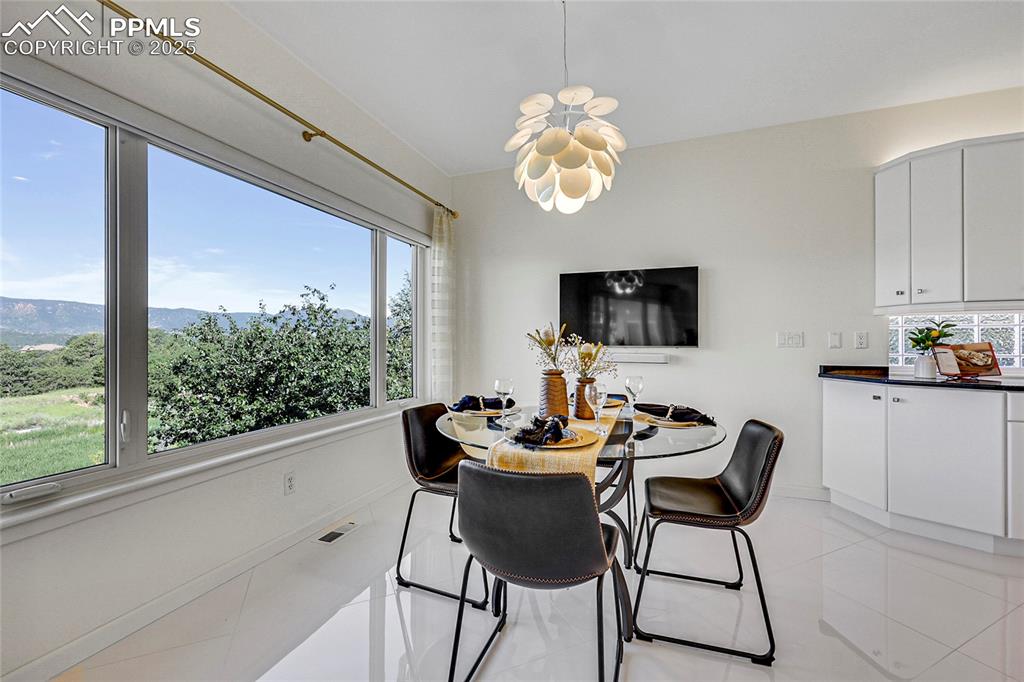 Image 17 of 48: Dining room with light tile patterned floors and a chandelier