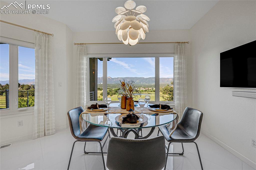 Image 19 of 48: Dining room with a chandelier, a mountain view, and tile patterned flooring