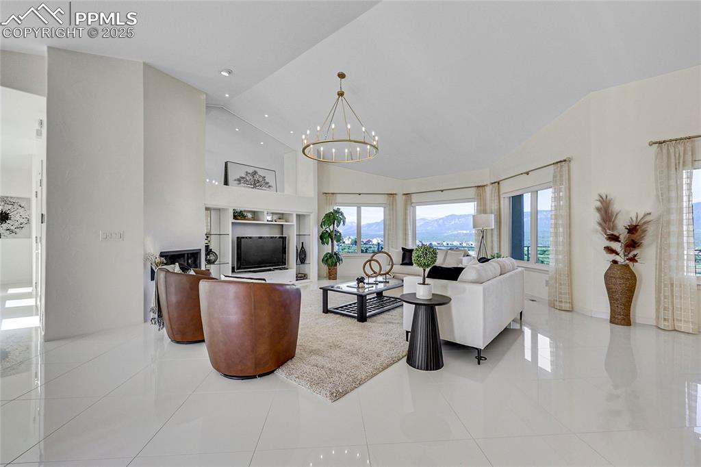 Image 5 of 48: Living area with a chandelier, high vaulted ceiling, recessed lighting, and