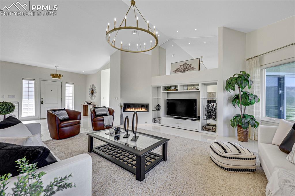 Image 6 of 48: Living room featuring a chandelier, recessed lighting, a towering ceiling,