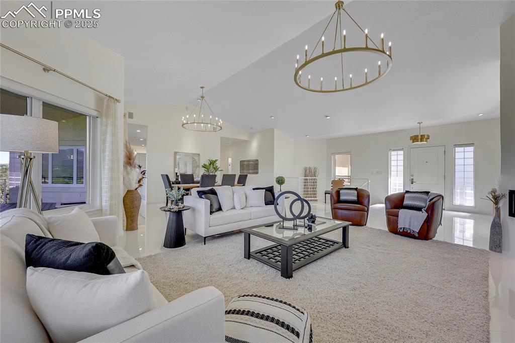 Image 7 of 48: Living area featuring a chandelier and lofted ceiling