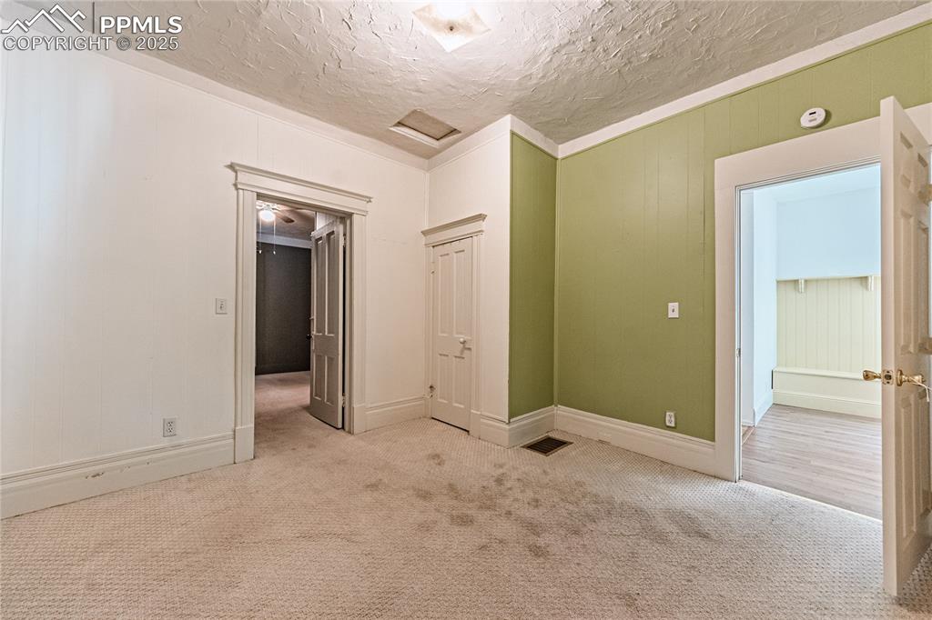 Image 15 of 36: Carpeted empty room featuring a textured ceiling and a smoke detector