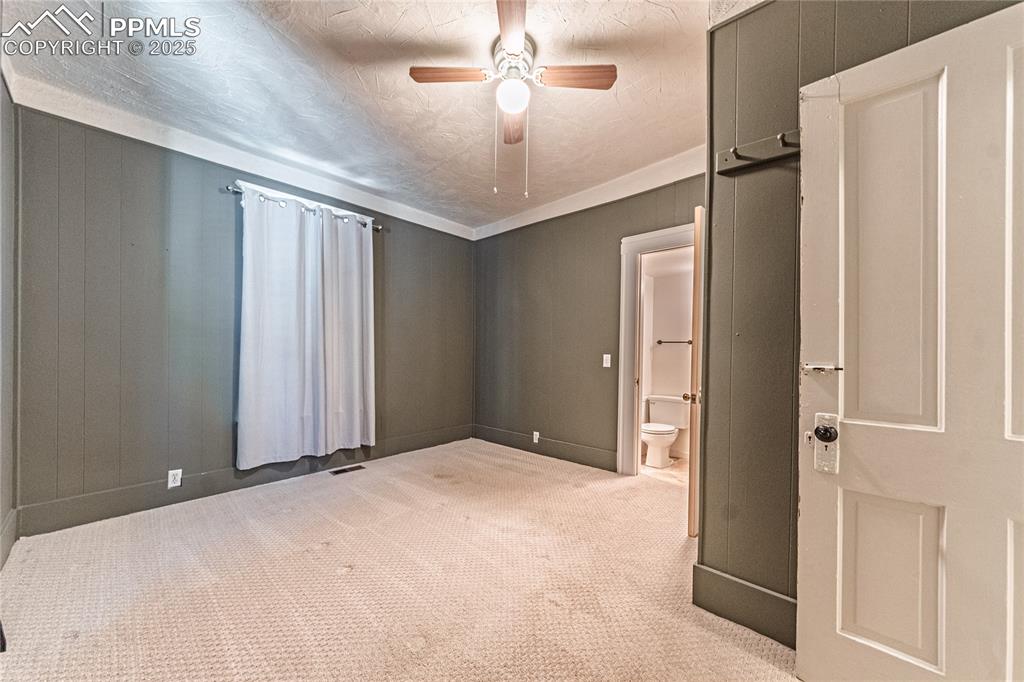 Image 17 of 36: Unfurnished bedroom with carpet floors, a ceiling fan, and connected bathro