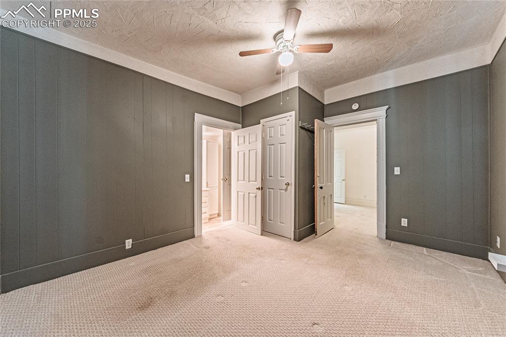 Image 18 of 36: Unfurnished bedroom featuring carpet flooring, a ceiling fan, and a texture