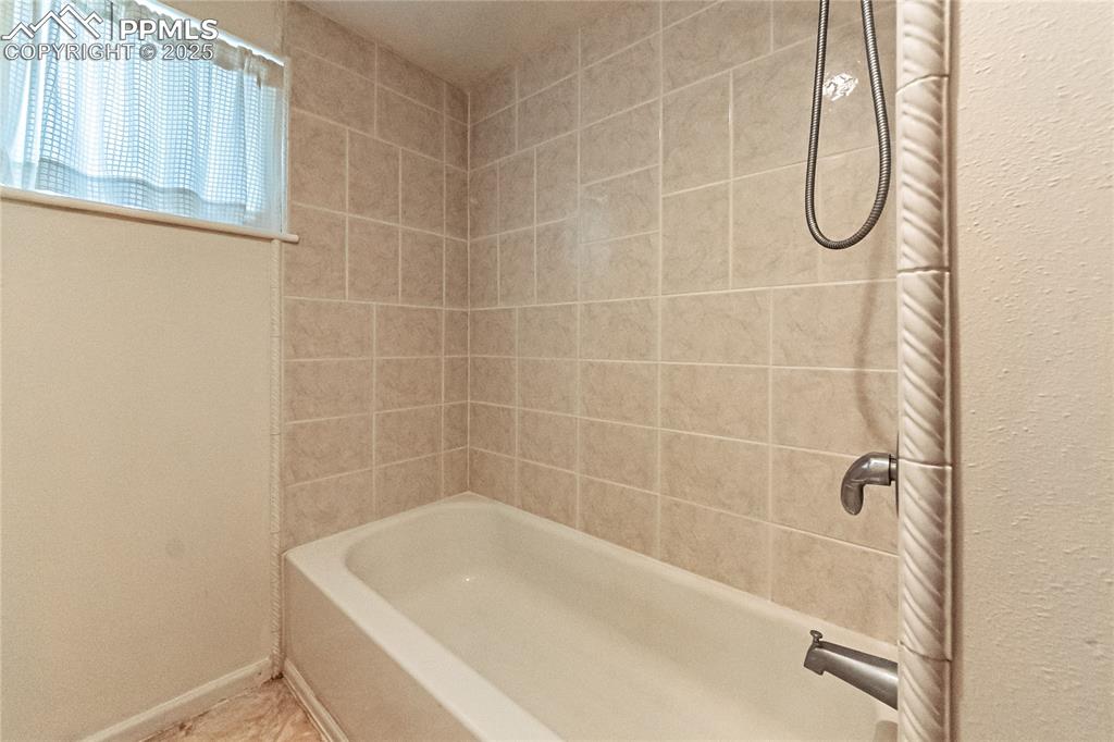 Image 21 of 36: Bathroom featuring shower / washtub combination