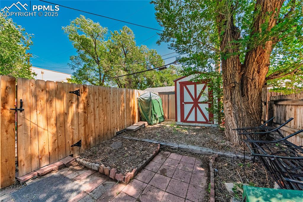 Image 29 of 36: Fenced backyard with a shed