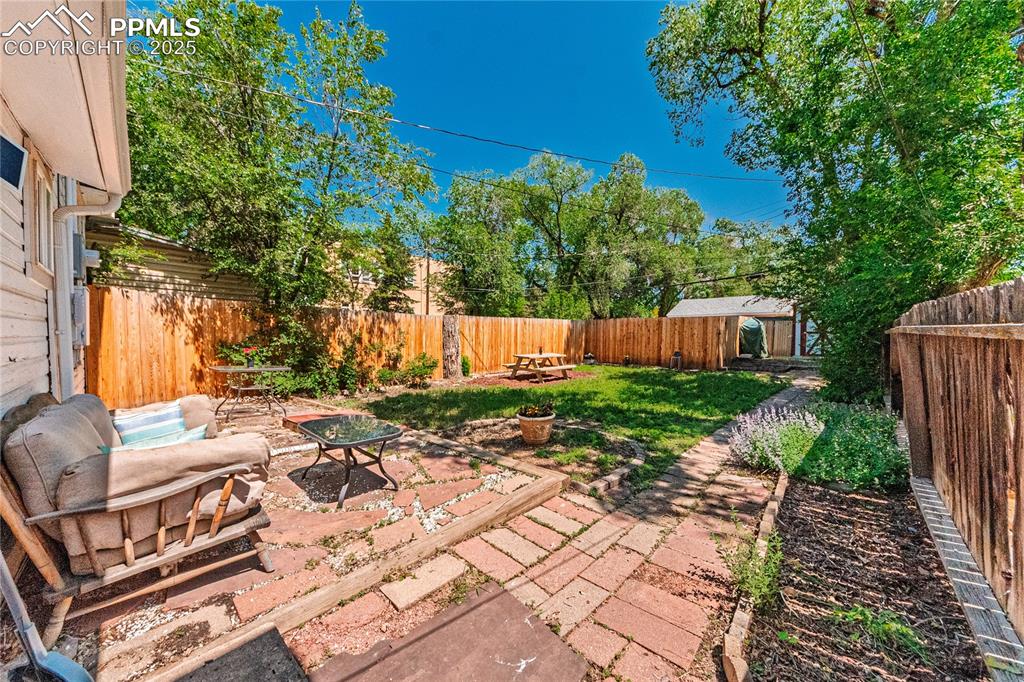 Image 5 of 36: Fenced backyard with a patio